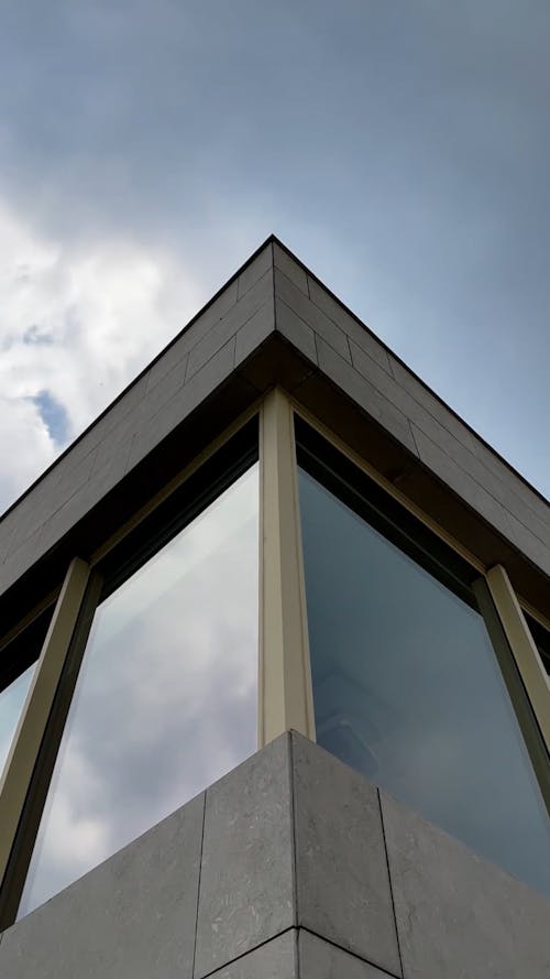 Low Angle View of a Building Corner under a Cloudy Sky 