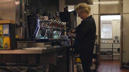 Woman making coffee in cafe 