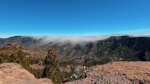 Looking to clouds in background passing above the edge of a mountain - Gran Canaria