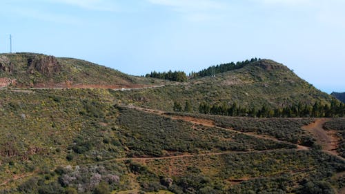 Drone flight from the edge of a mountain to an old crater covered with fields - Gran Canaria