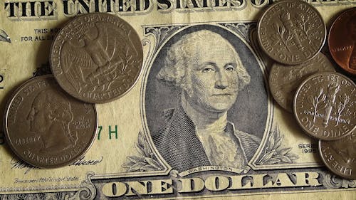 Close-up View Of A Dollar And Coins