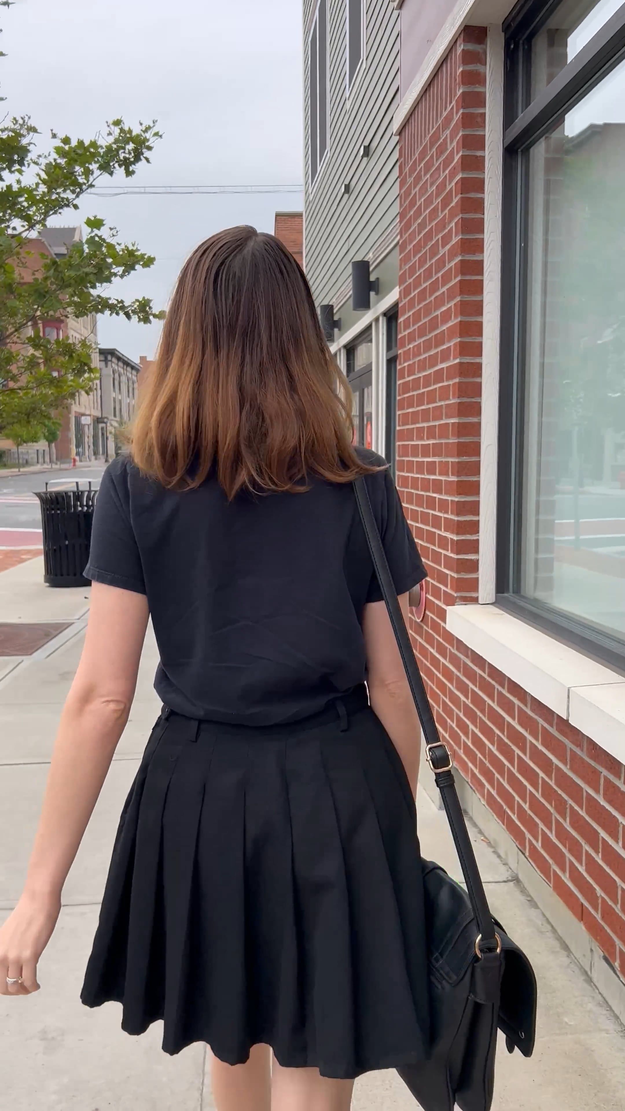 A woman walking down the sidewalk in a black dress Free Stock Video ...