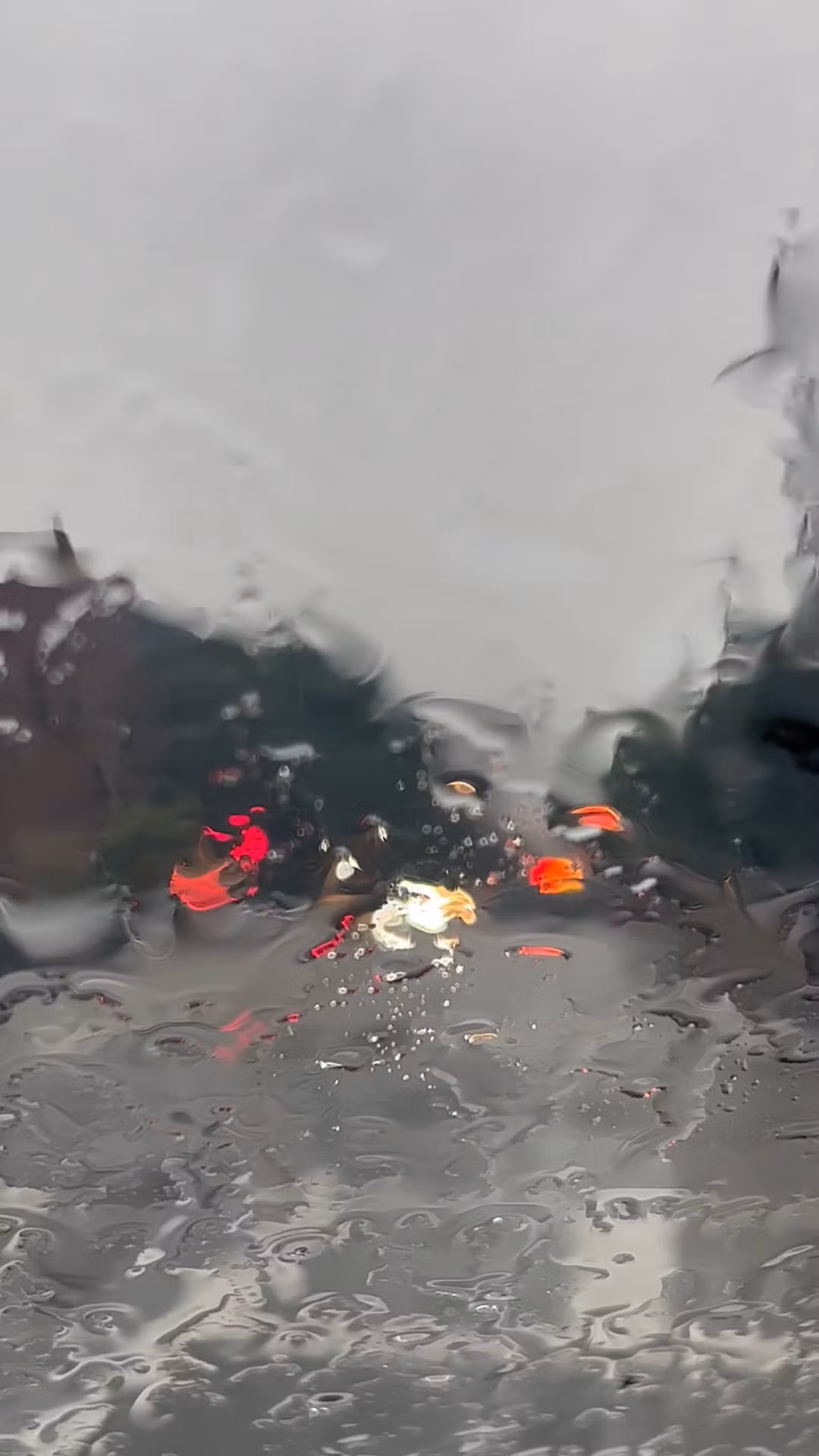 a car is driving down a street in the rain 18127383