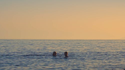 Couple on the Mediterranean Sea during orange sunset