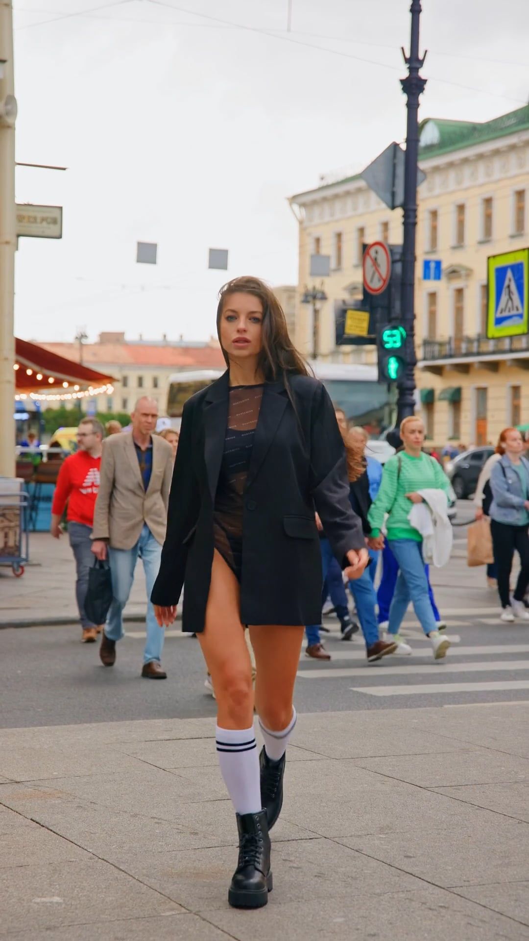 A woman in a black jacket and high socks walking down the street Free ...