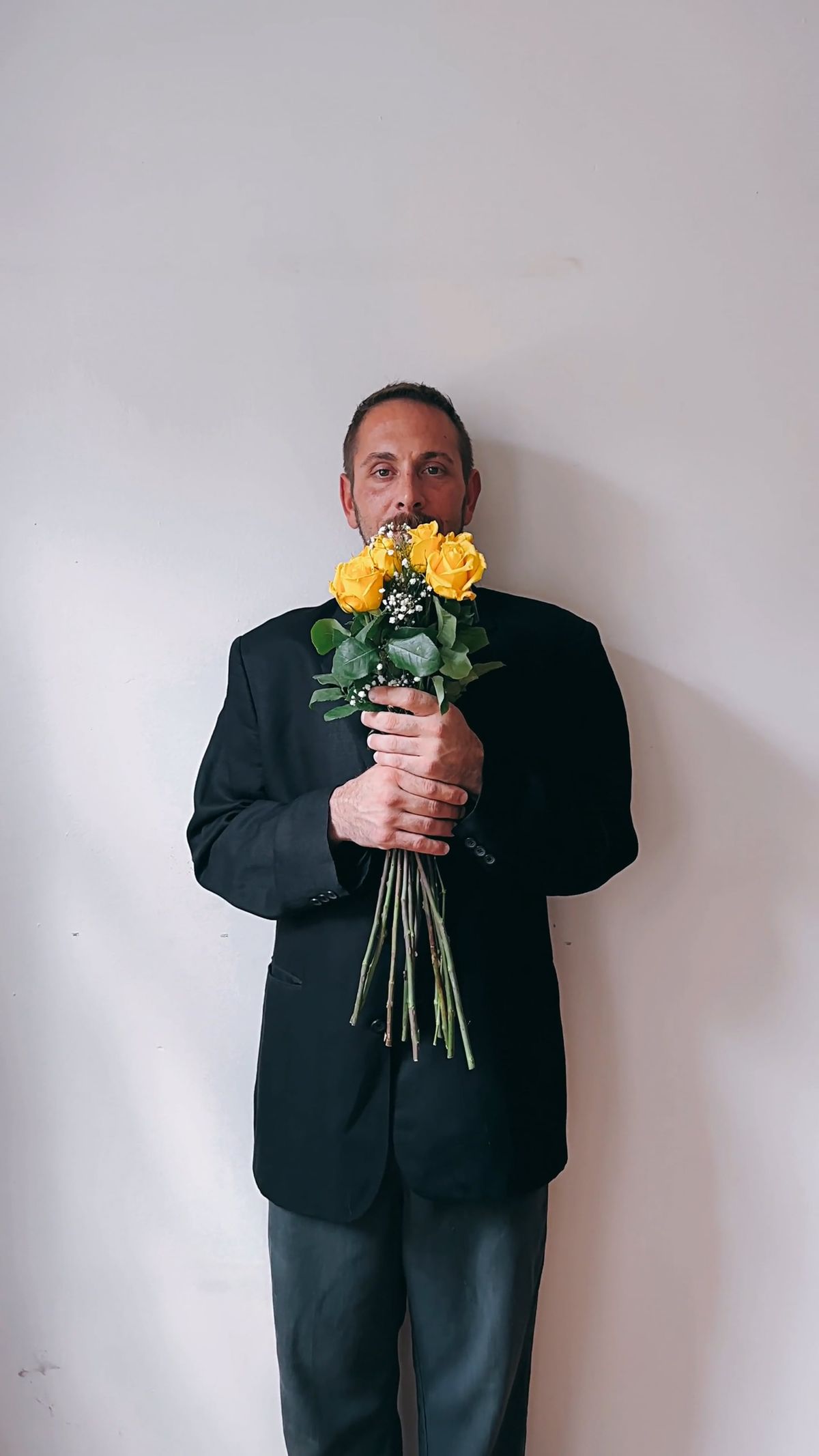 A man standing in front of a wall with flowers Free Stock Video Footage ...