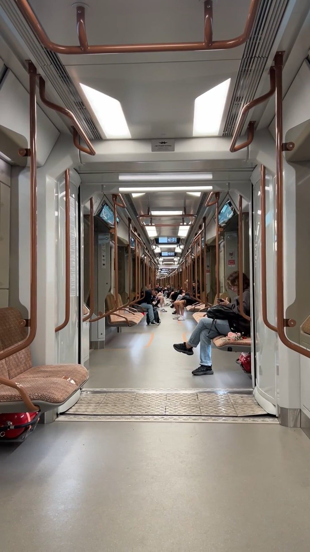 A train with people sitting on the floor and some people sitting on the ...