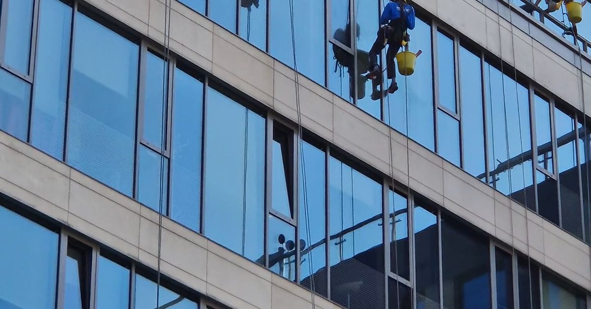 A group of people are cleaning windows on a tall building Free Stock ...