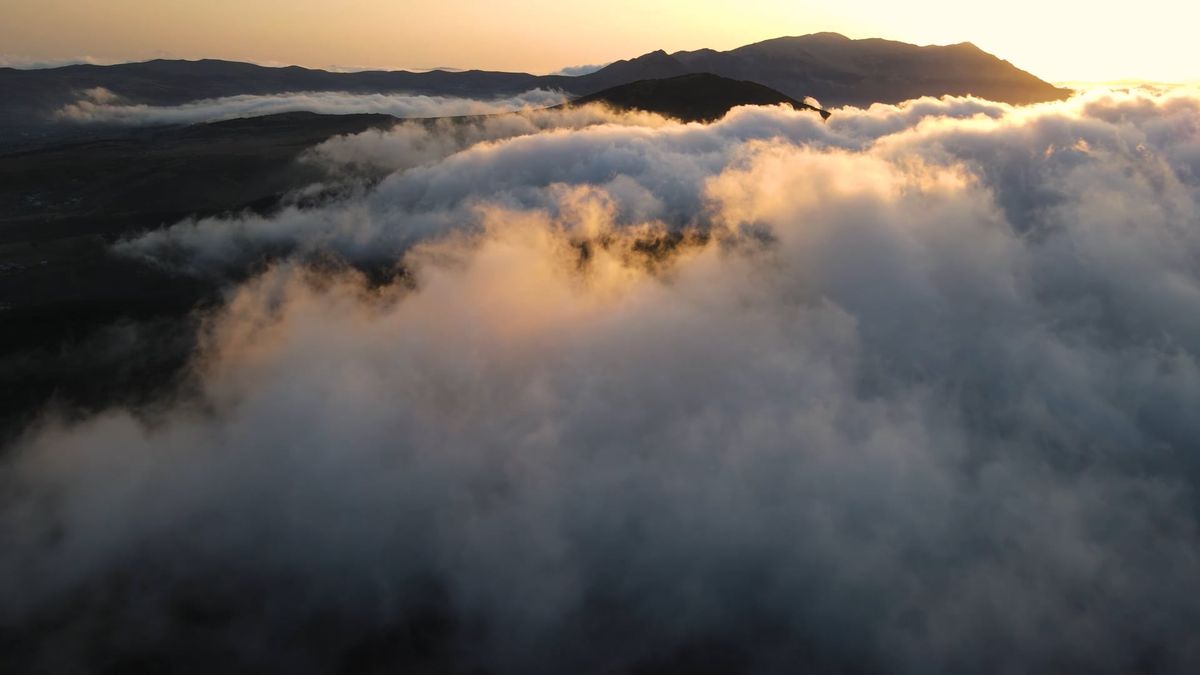 Aerial view of the fog and clouds over the mountains at sunset Free ...