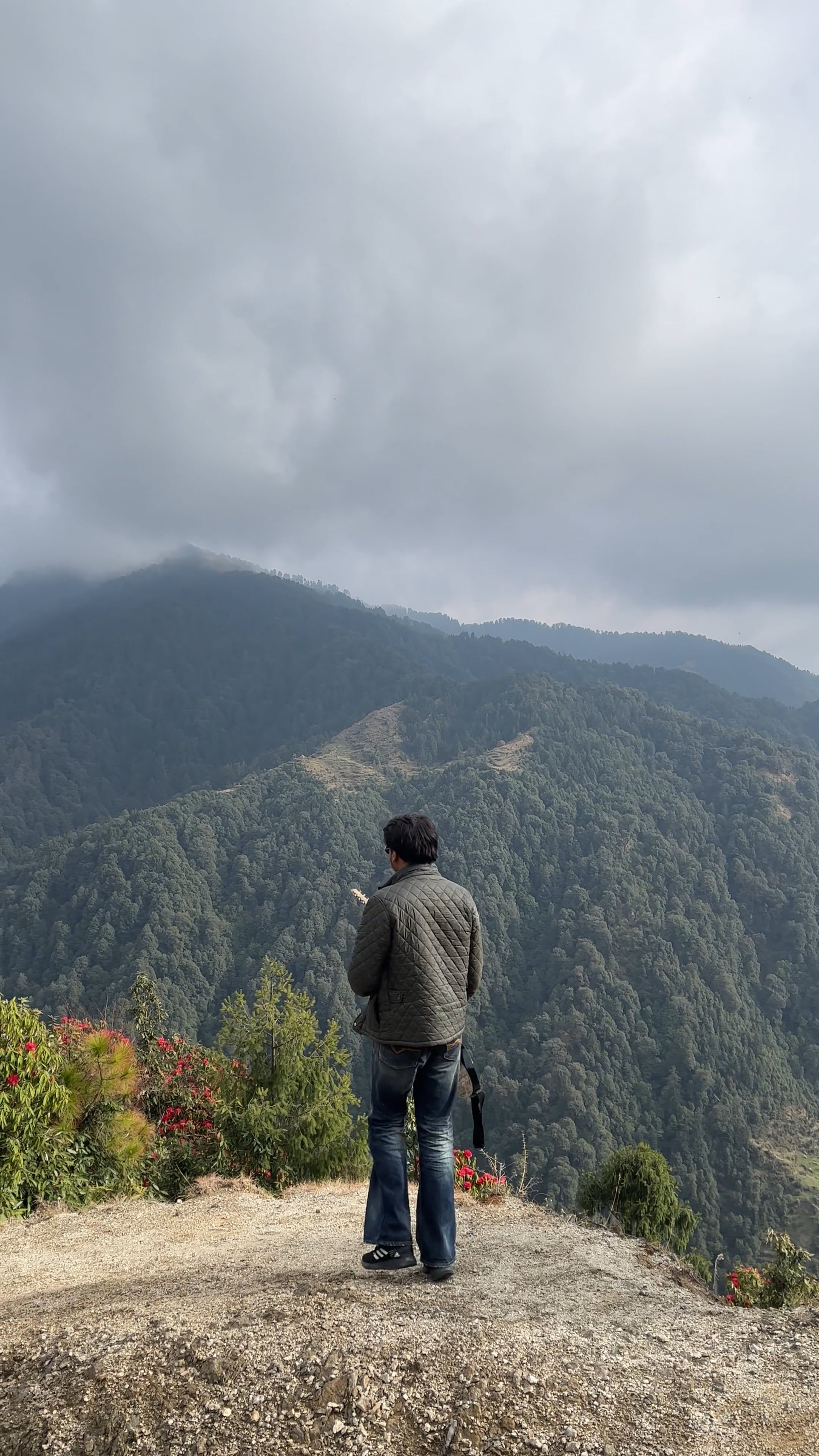 a man standing on top of a mountain with a view of the clouds 18365266