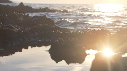 Shore sunset and sun surface reflection, slow motion