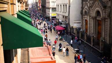 a crowded city street with people walking and cars