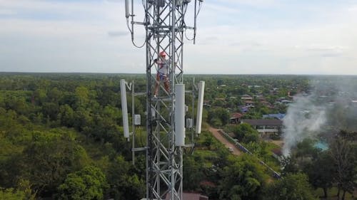 Man Working On A Tower With View Of Landscape