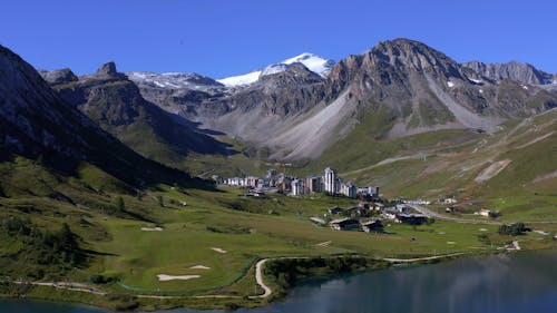 Tignes - Flying with a drone above the lake of Tignes and discovering a beautiful view of the Val Clarey district and the Grande Motte mountain in bakcground