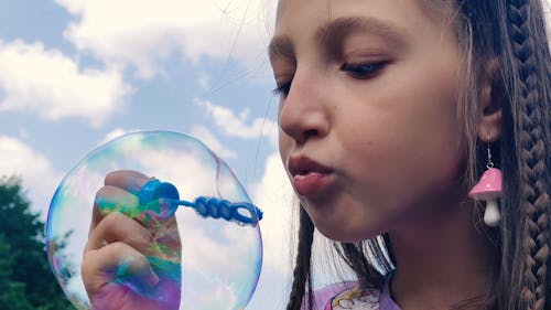 Little girl blowing soap bubbles. child blowing soap bubbles