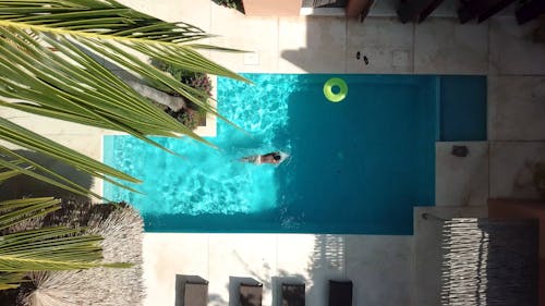 Drone shot of a person Swiming in a pool