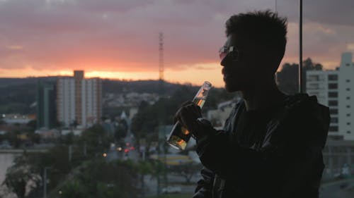 Man Drinking With Sunset Background