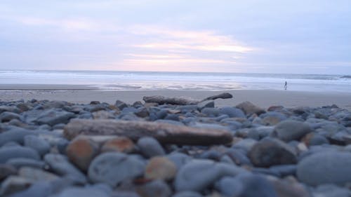 Low Angle Shot D'une Plage Avec Des Pierres Sur La Rive