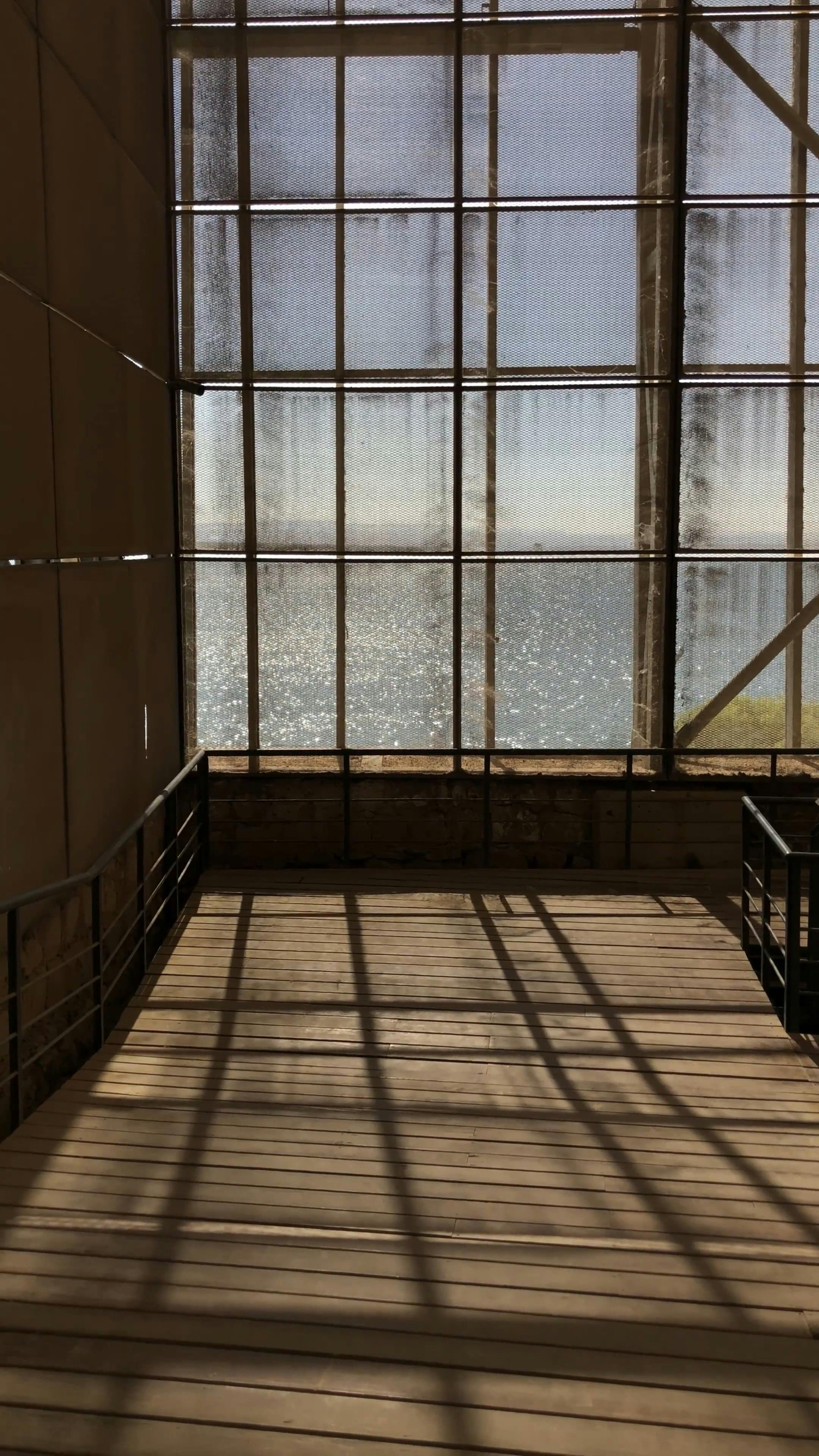 a window with a view of the ocean and a bench 19002234