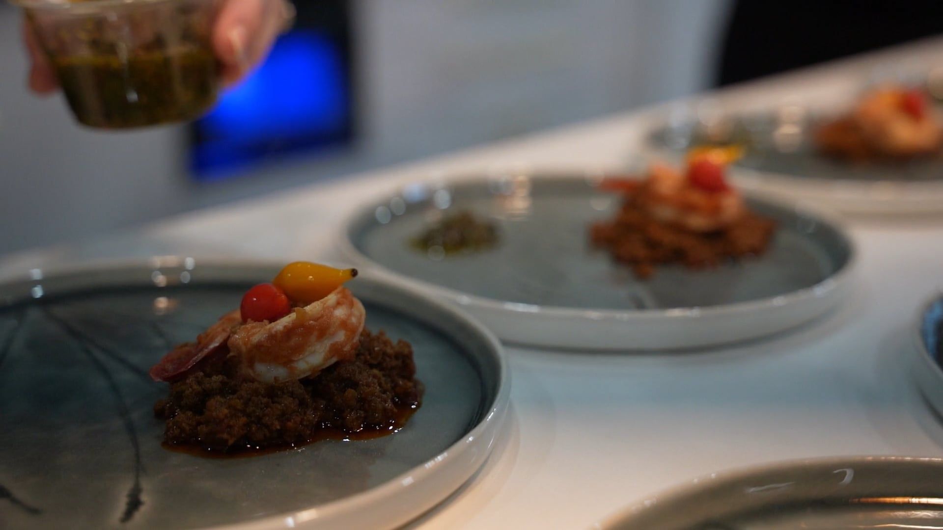 Composed plates being finished in a professional kitchen