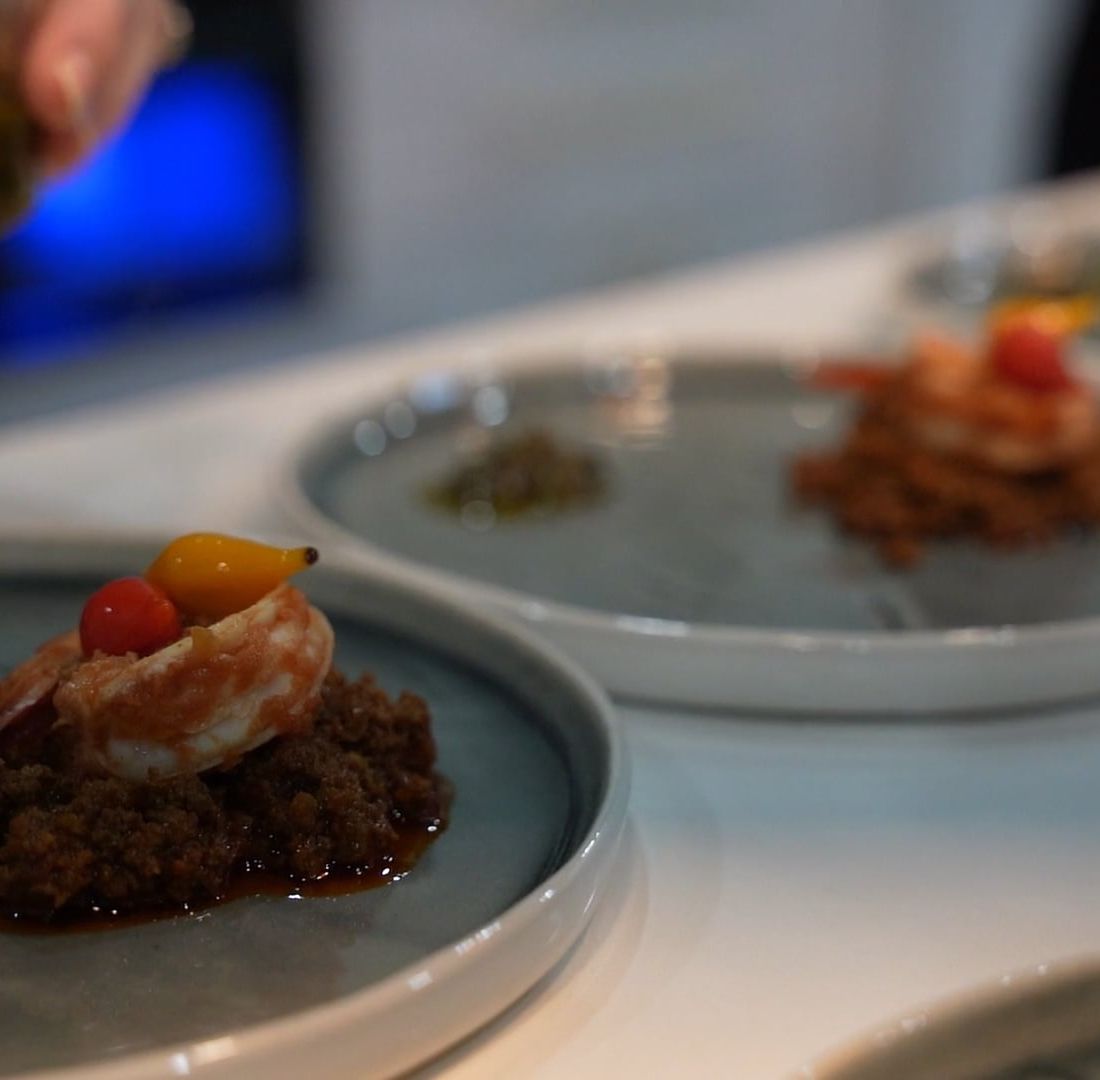 Composed plates being finished in a professional kitchen