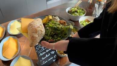 a woman is holding a plate of food on a table