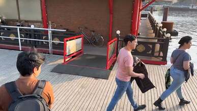 a man walking on a dock with boats and people
