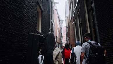 a group of people walking down a narrow alley