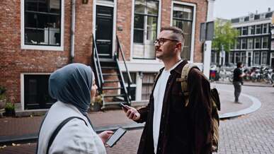 a man and woman are talking in a street