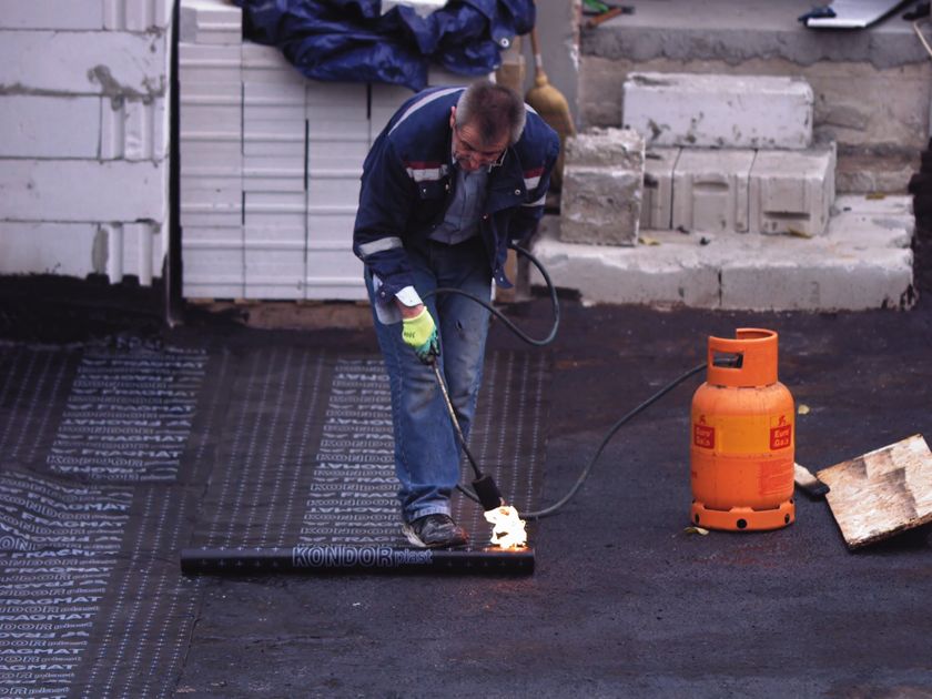 Technician washing down a flat surface during a moss treatment visit