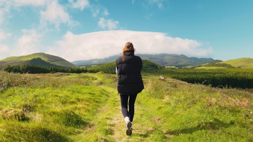Girl walking in the breathtaking green landscape of Terceira Island, Açores