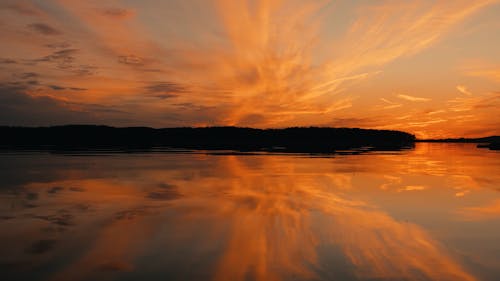 Calm Water Reflection Of Golden Sunset On Lake