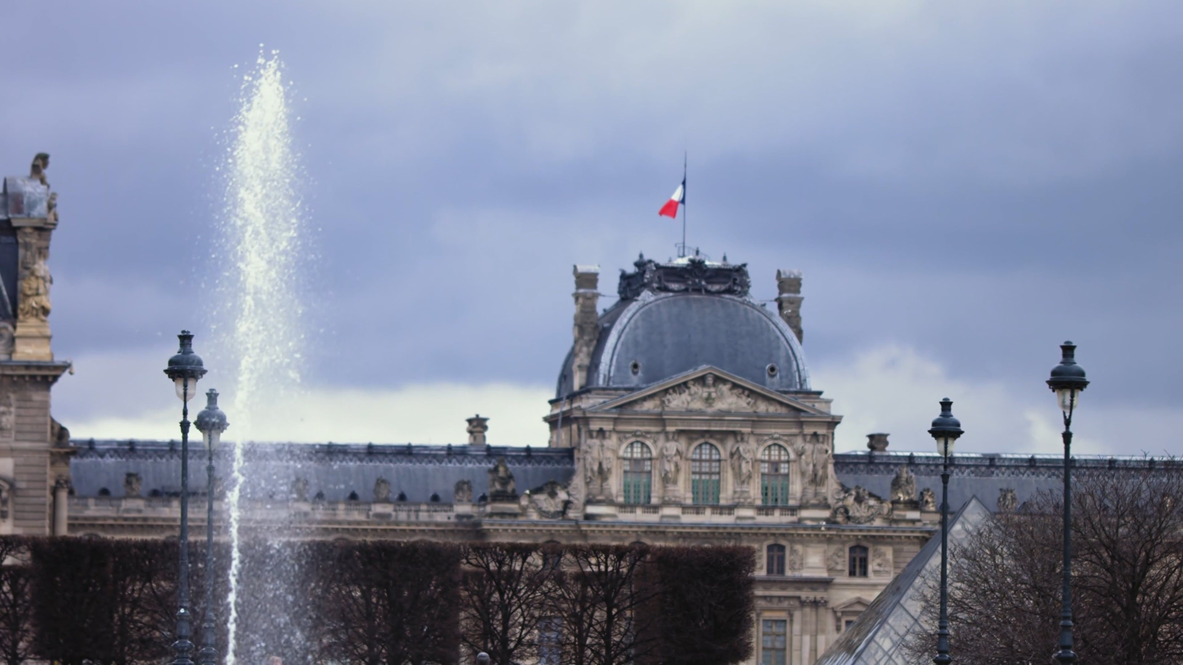 Pavillon du Louvre et drapeau français derrière la fontaine des Tuileries