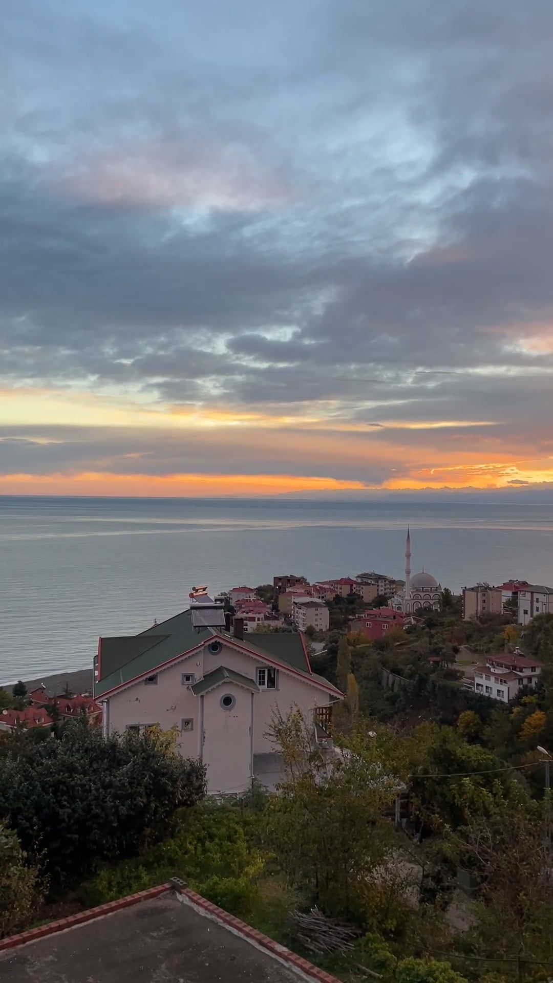 the sun sets over the ocean and hills 19545181