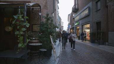 people walking down a narrow street in a city