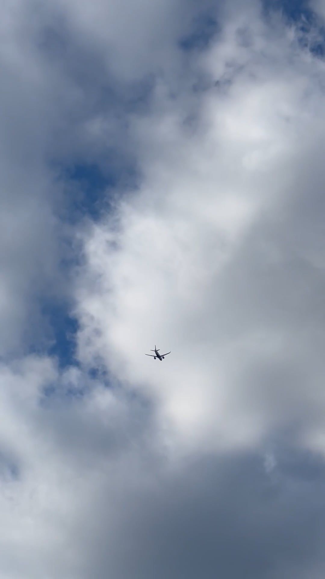 A plane flying through the cloudy sky with a blue sky Free Stock Video ...