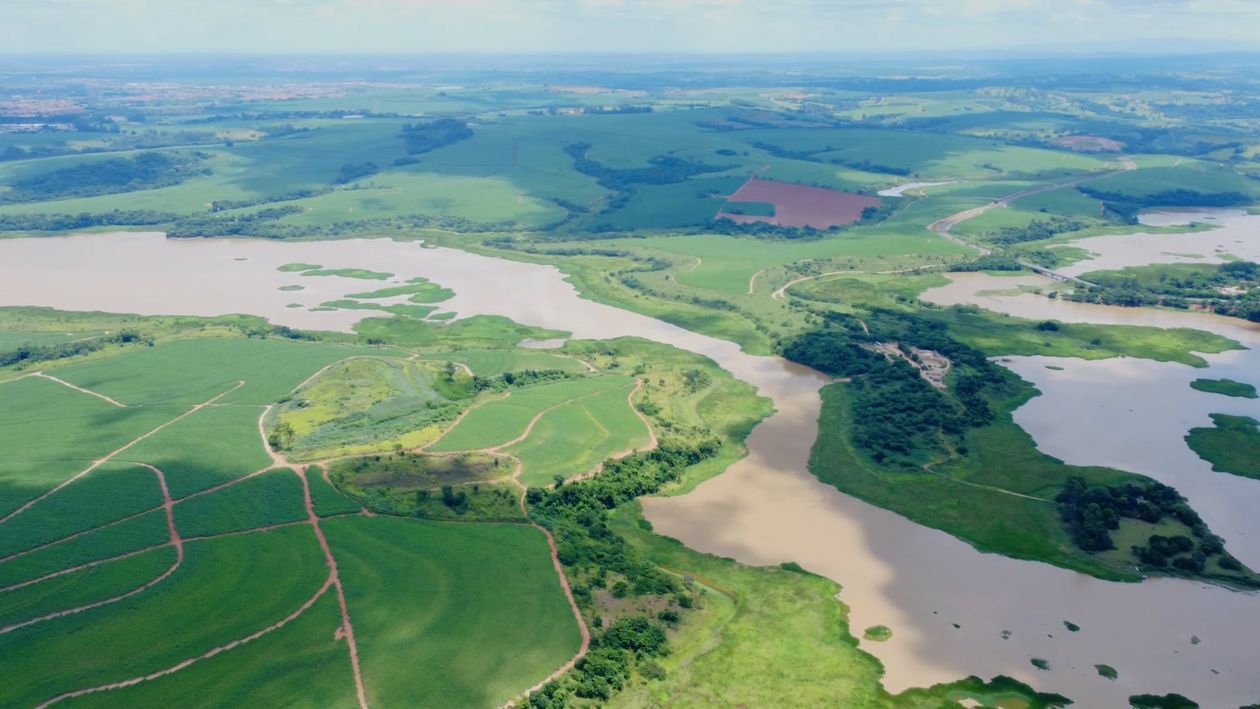 An aerial view of a green field with a river Free Stock Video Footage ...