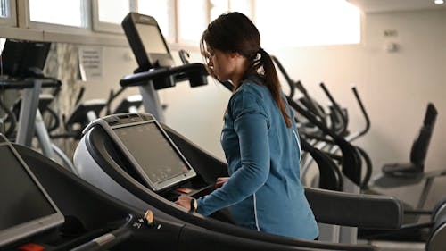 A girl walks on a treadmill in the gym