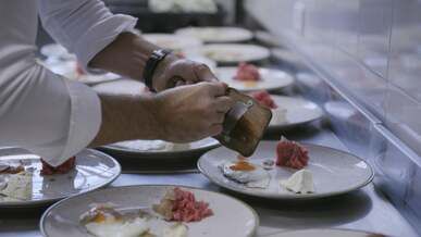a chef is preparing food on plates