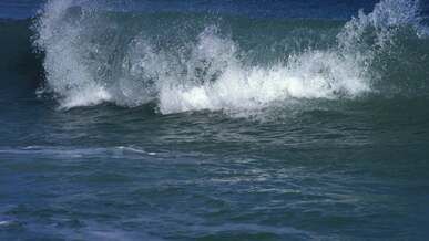 a wave is crashing on the beach