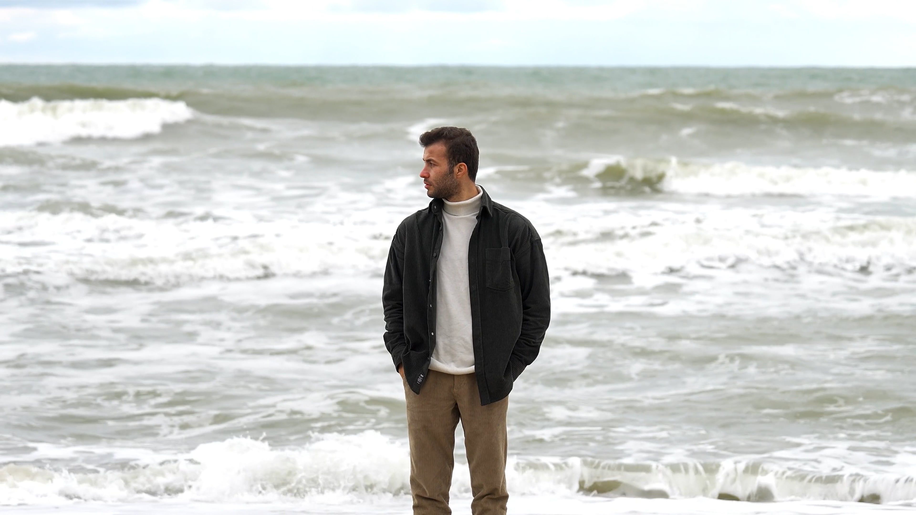 A man standing on the beach in front of the ocean Free Stock Video ...
