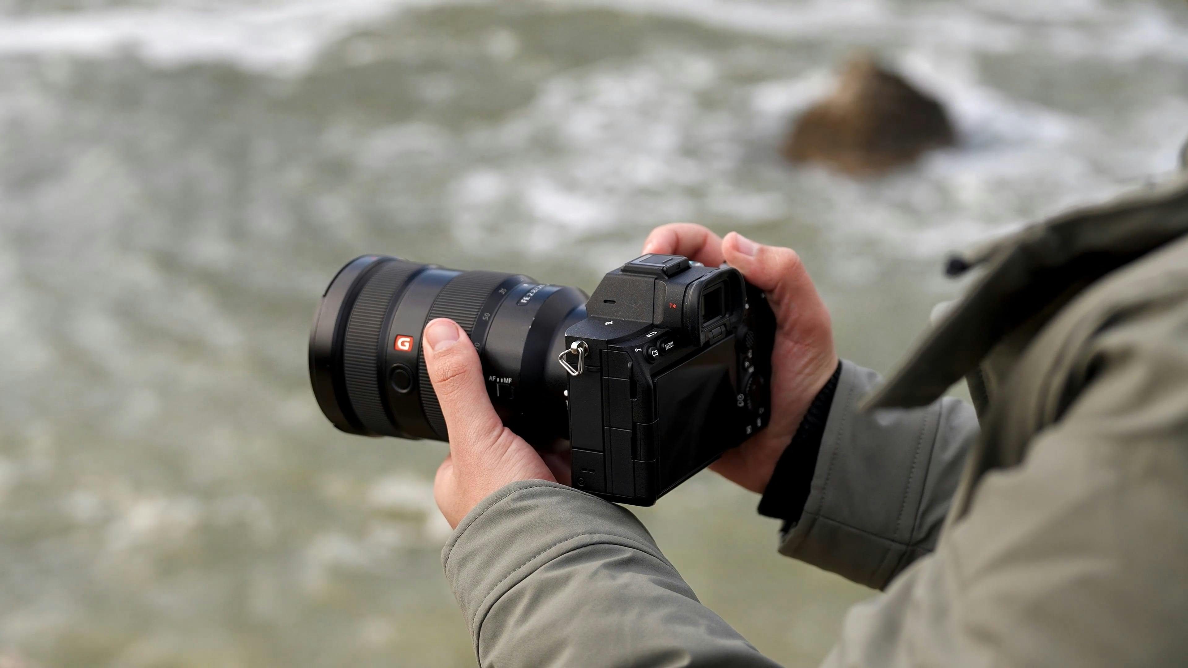 A person holding a camera in front of the ocean Free Stock Video ...