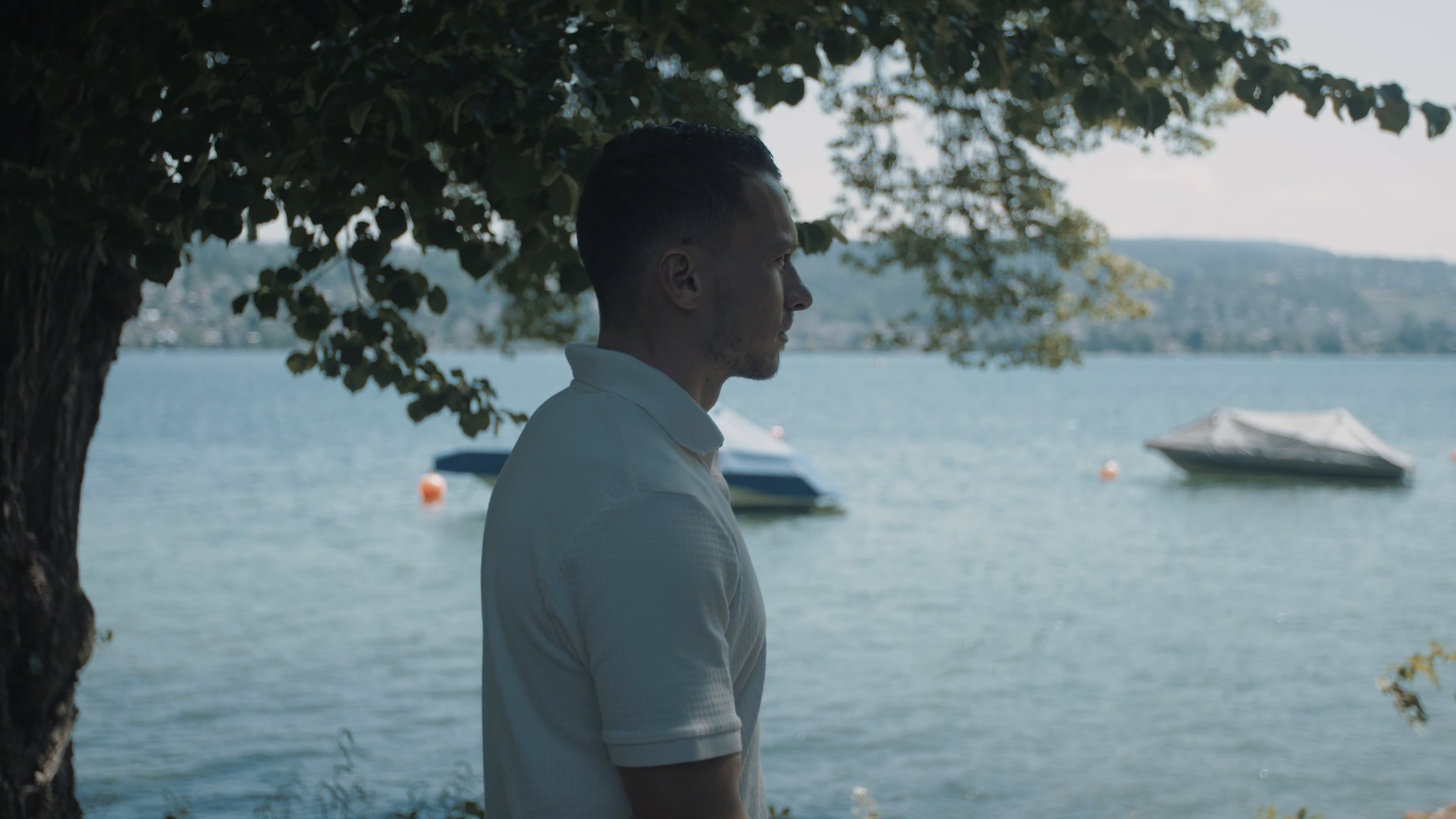 A man standing by the water with a boat Free Stock Video Footage ...