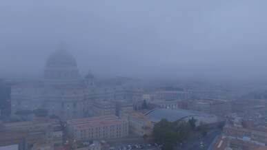 a city in the fog with buildings and a church