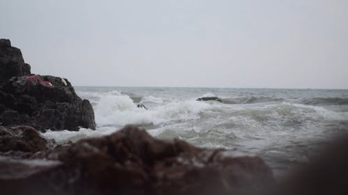 Close-Up View Of Waves Crashing To The Rocks