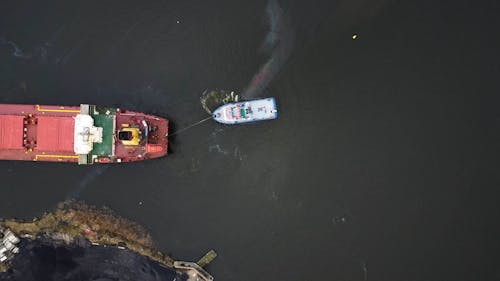 aerial view of vessels maneuvers with tugboat in port