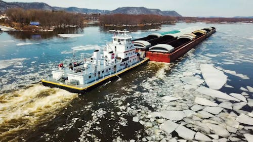 Ein Lastkahn, Der Den Fluss Mit Eisbergen Segelt