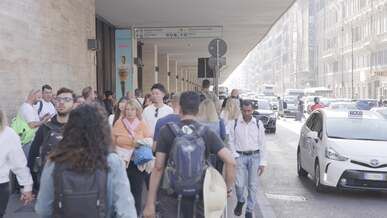a group of people walking down a sidewalk