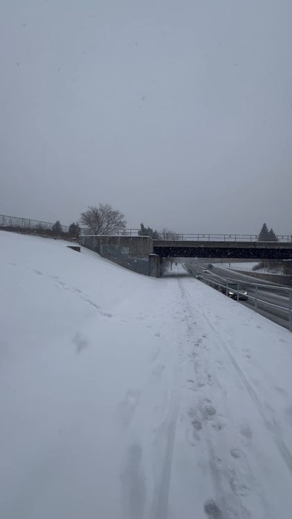 A snow covered road with a bridge in the background Free Stock Video ...