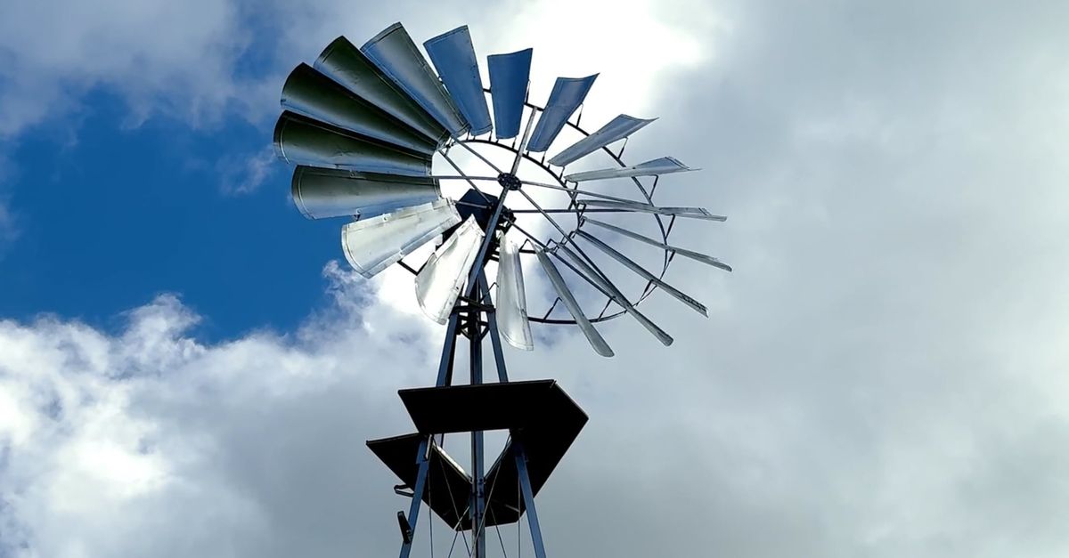 Windmill Video A windmill on top of a metal pole with clouds in the sky Free Stock ...